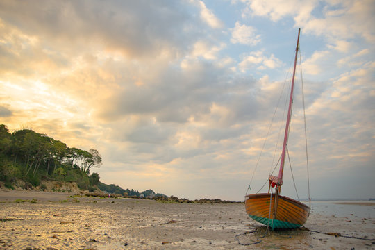 A sail boat resting a low tide