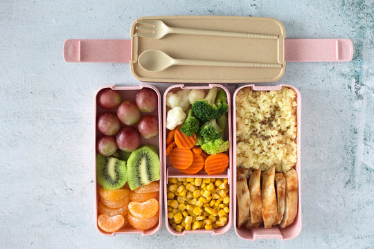 Porridge, chicken, salad, fruits - healthy balanced lunch box on a grey background. Home made food for office