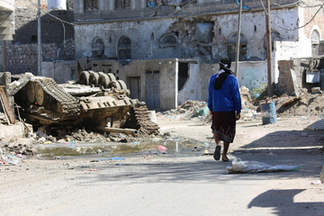 A Yemeni walking amid the great devastation caused by the war  in Taiz, Yemen
