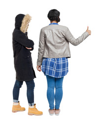 Back view of two young girl in winter jacket showing thumb up.