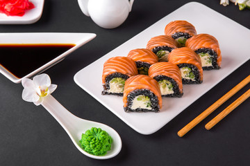 Philadelphia Sushi Roll made of Fresh Salmon, Avocado and Cream Cheese with black rice with cuttlefish ink inside. Traditional Japanese cuisine. Asian food