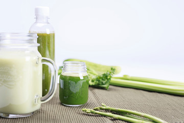 healthy eating, vegetarian food and diet concept - close up of glass with green juice, fruits and vegetables on table