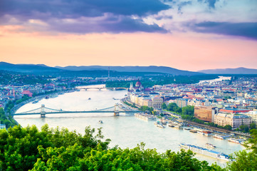 Obraz premium A view along the Danube River of Budapest, Hungary from Gellert Hill at sunset.