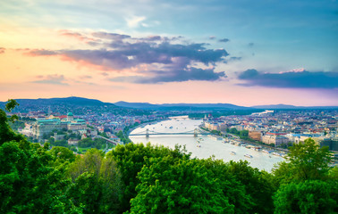 Obraz premium A view along the Danube River of Budapest, Hungary from Gellert Hill at sunset.