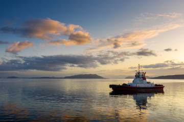 Tugboat Anchored in the San Juan Islands During a Beautiful Sunset. Tugboats escort oil tankers through the San Juan Islands to prevent accidental spills and groundings.