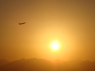 The amazing sunset is near the flying plane, Egypt