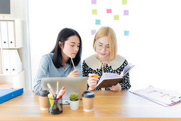 Fototapeta premium attractive asian female officer reviews information of organization performance, they sharing knowledge and learning to development, they feeling happy and smile, happiness organization