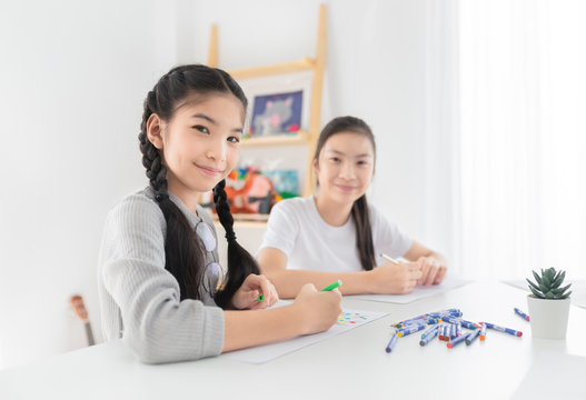 asian children training to drawing and paint image, they feeling happy and smile, they use pencil and crayon color in art training time