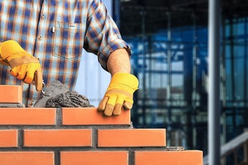 Bricklayer worker installing brick masonry