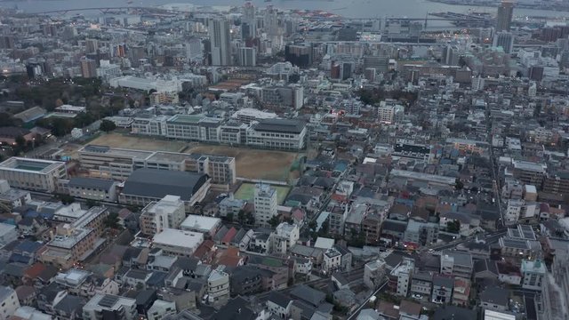 Aerial rise revealing Kobe city at twilight in Japan