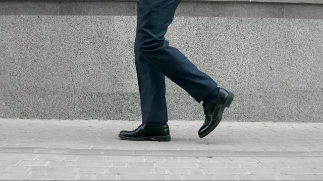 Business man legs walking in black shoes. Closeup black shoes walking outdoor