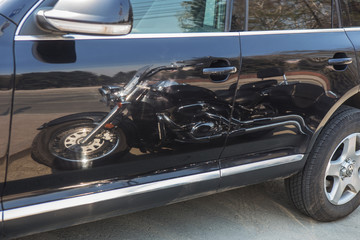 reflection of the motorcycle on the side of the car