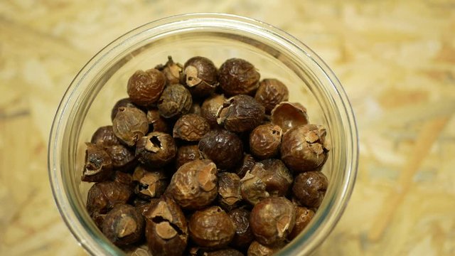 Soap nuts Indian soapberry or washnut glass jar cup, Sapindus mukorossi reetha or ritha from the soap tree shells are used to wash clothes to put drum washing machines. Nuts saponin plant fruit seeds