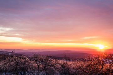Vivid stunning sunset at High Point State Park, top of NJ, first day of winter covered in ice and snow