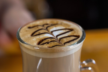 cup of coffee with cream on wooden background