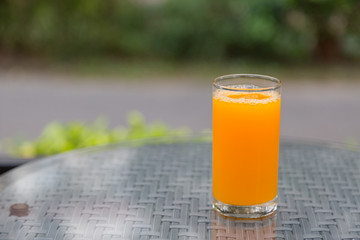 Orange juice glass on the table glass with green