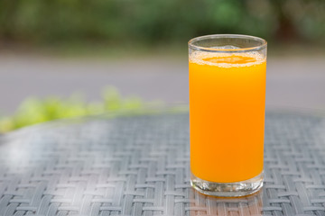 Orange juice glass on the table glass with green