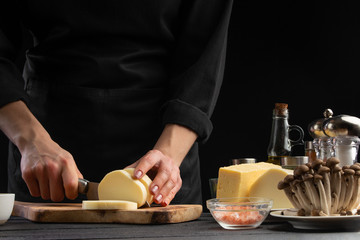 Chef slices mazzarella cheese to prepare a delicious and fresh salad. Vegetarian and fresh food,...