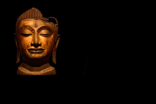 Buddha head image on black background.
