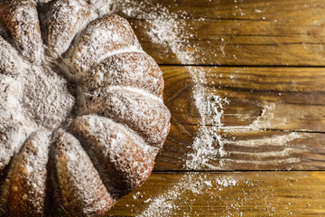 Italian traditional Christmas cake panettone torta pandoro powdered with vanilla on wooden table.