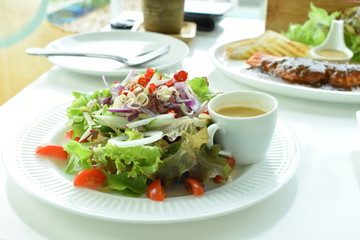 fresh salad with cheese and olives on white plate