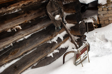 Log wall and sleigh covered with snow, abstract background