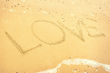 Napis Love na piasku na plaży.