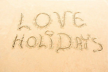 Odręczny napis holidays - wakacje na piasku nad morzem