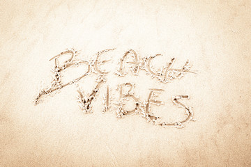 Ręczny napis na piasku na plaży Beach Vibes. Handwriting on the sand at the beach Beach vibes