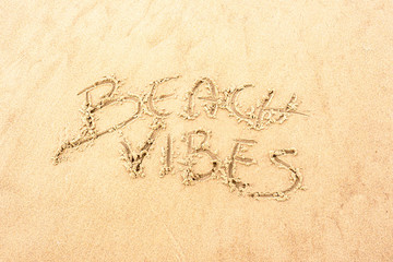 Ręczny napis na piasku na plaży Beach Vibes. Handwriting on the sand at the beach Beach vibes