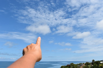hand pointing to the sky on blue background