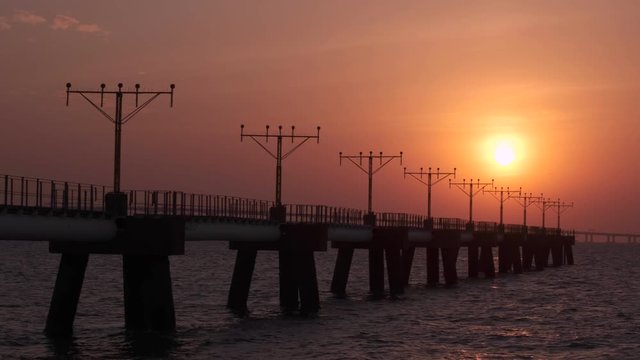 Pan shot of the approach lighting system towers at sunset.