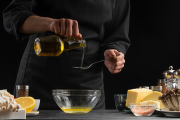 Chef pours olive oil for making sauce or dressing for making a delicious and fresh salad....