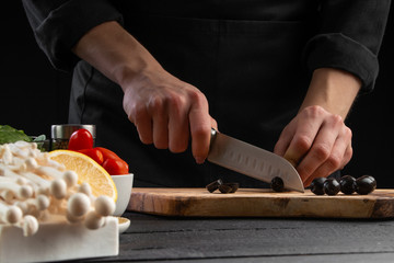 The chef cuts Italian masks to prepare a delicious and fresh salad. Vegetarian and fresh food,...