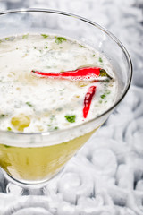 Close up with a margarita with spicy red peppers in a martini glass