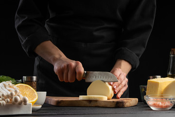 Chef slices mazzarella cheese to prepare a delicious and fresh salad. Vegetarian and fresh food,...