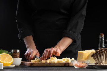 Chef slices mazzarella cheese to prepare a delicious and fresh salad. Vegetarian and fresh food,...