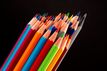 Fototapeta premium Colored pencils for drawing on a dark background. Education and creativity. Leisure and art