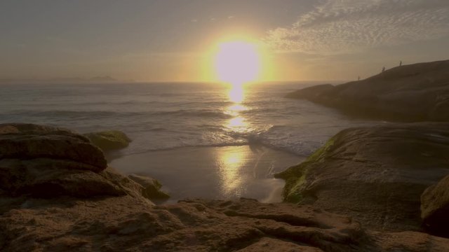 Time lapse of sunrise at the small cliff beach between the rocks of Arpoador in Rio de Janeiro, Brazil