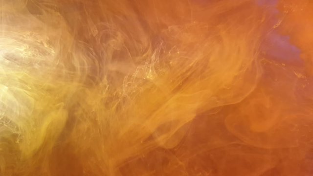 saturated orange color acrylic ink flowing into water, heavily pigmented and beautiful colors make for pretty multi colored clouds for background footage.