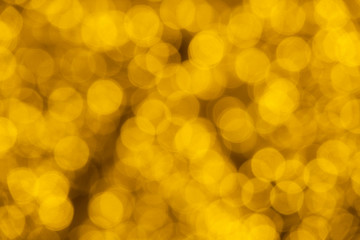 Defocused of blurred golden bokeh circle light from lighting bulb Merry Christmas and Happy New Year decorative in the night for abstract background texture