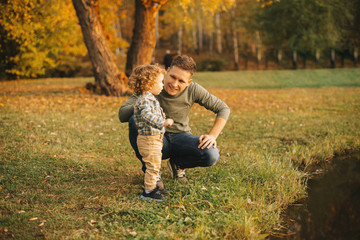 Fototapeta premium Photo of smiling father with little son in park having fun