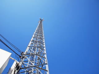 Fototapeta na wymiar Telecommunication tower and low voltage cables With electronic devices of wireless communication systems, 3 G, 4G and 5G mobile networks on a blue sky background With the copy space. Selective focus