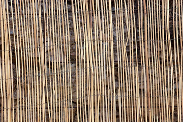 decorative straw fence covering a stone wall
