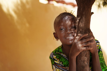 Light Effects On A Smiling African Girl's Face Clinging To A Tree Trunk 
