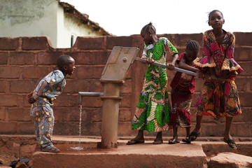 African Children Having Fun At The Water Pump - obrazy, fototapety, plakaty