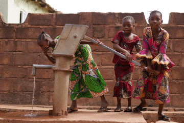 Three Eager Little African Girls Trying Out Their Village Water Pumping Station © Riccardo Niels Mayer