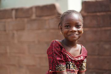Smiling African Girl With a Wet Face After Having Taken A Sip From The Water Borehole - obrazy, fototapety, plakaty