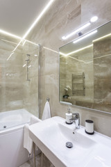 water tap sink with faucet in expensive loft bathroom. detail of a corner shower cabin with wall mount shower attachment