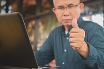 Businessman thump up and using computer working by internet technology